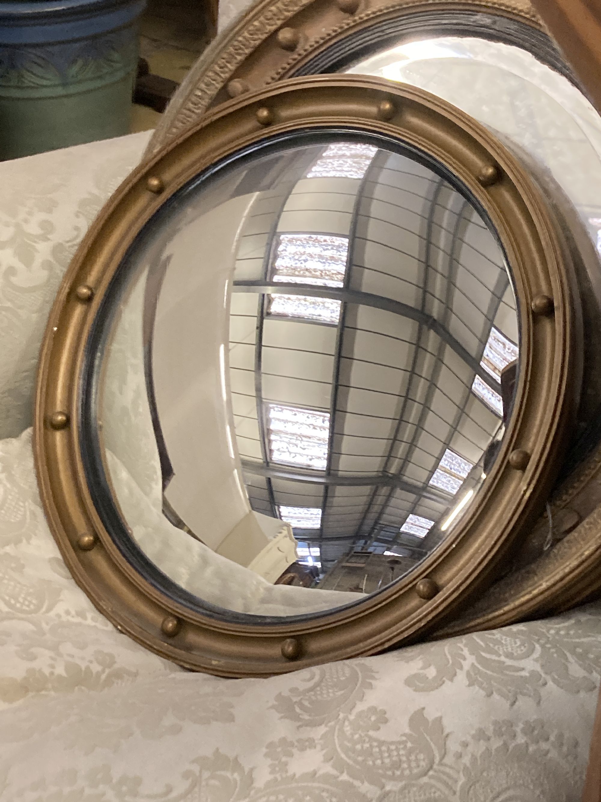 Four circular gilt framed convex and wall mirrors, largest 50cm diameter